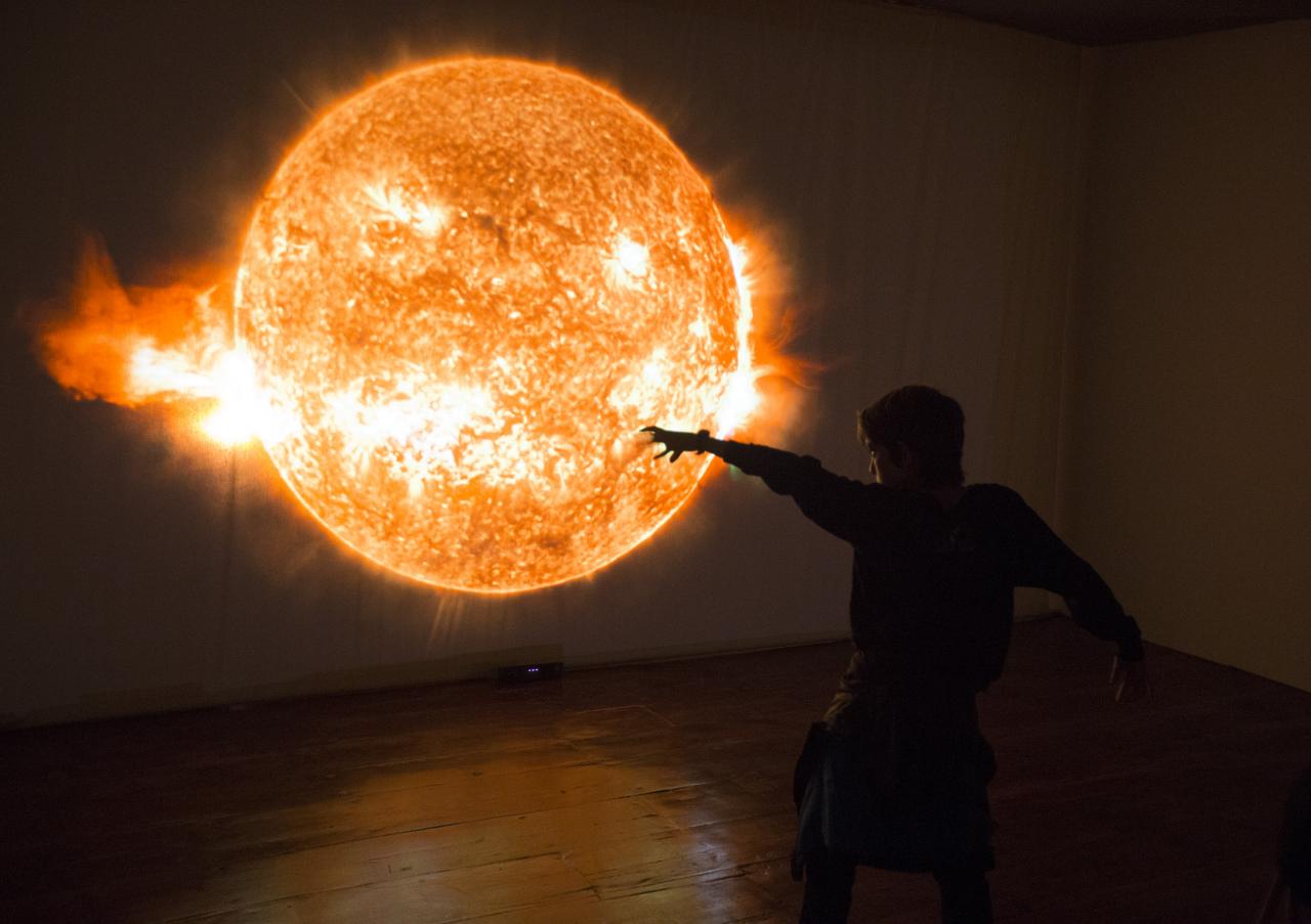A child playing in front of the interactive module "Solar Immersion" in the "Lights of the Universe" exhibition. Credits: Daniel López/IAC.